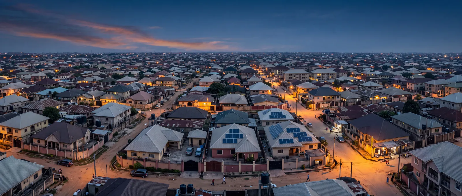 Aerial view of a Nigerian neighbourhood at dusk, solar panels on several rooftops